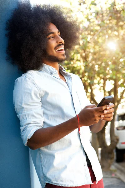 Homme appuyé contre le mur avec téléphone portable — Photo