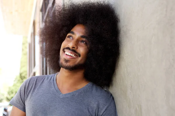 Man with afro leaning against wall — Stock Photo, Image