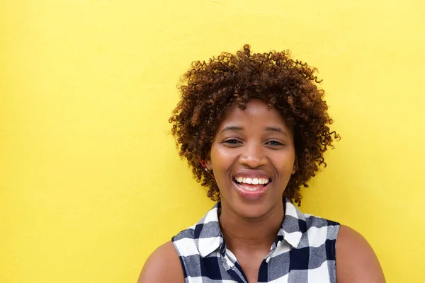 Kadın sarı duvara gülüyor — Stok fotoğraf