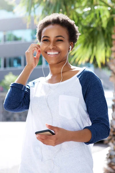 Kvinnan ler och lyssna på musik — Stockfoto