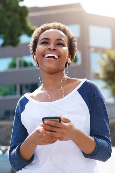 Woman smiling and listening to music — Stock Photo, Image
