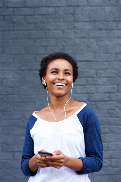 Mulher sorrindo e ouvindo música — Fotografia de Stock