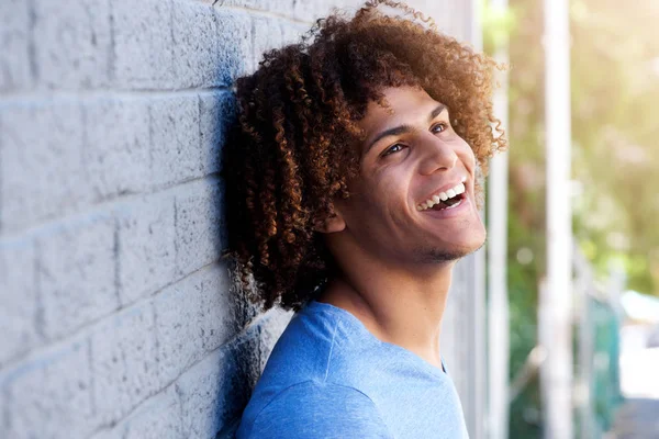 Молодой человек, смеющийся на улице — стоковое фото