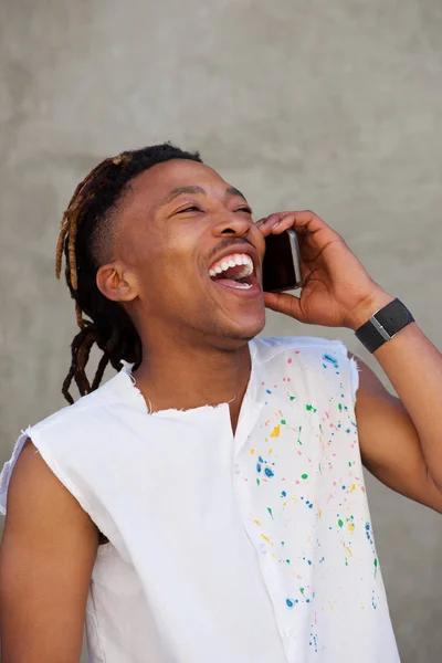 Mann mit Dreadlocks lacht und telefoniert — Stockfoto