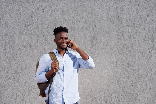 Homem com saco e celular em pé pela parede — Fotografia de Stock