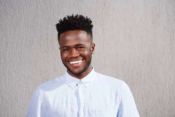 Homem sorrindo e de pé pela parede — Fotografia de Stock