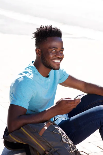 Man sitting outside with bag — Stock Photo, Image