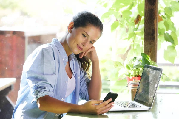 Donna seduta in possesso di smartphone — Foto Stock