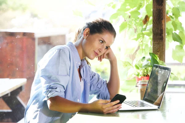 Femme avec ordinateur portable et smartphone — Photo