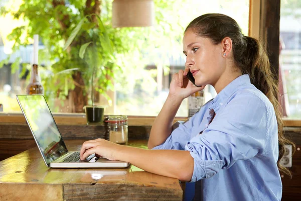 Femme parler et travailler sur ordinateur portable — Photo