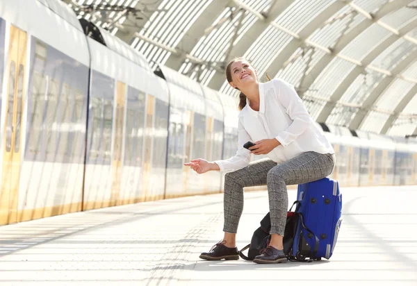 Vrouw zitten op een koffer met behulp van mobiele — Stockfoto