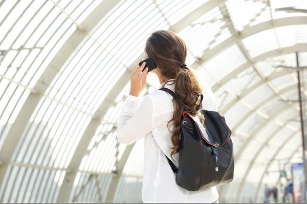 Woman with backpack talking on cellphone — Stock Photo, Image