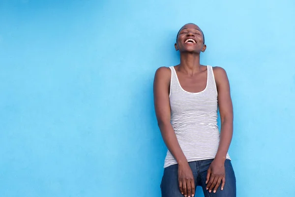Afrikanerin steht an blauer Wand — Stockfoto