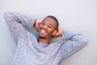 elleri başının arkasında olan adam