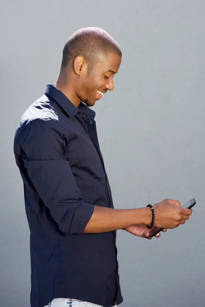 Uomo sorridente utilizzando il telefono cellulare — Foto Stock