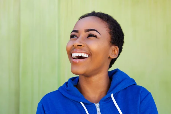 Frau lacht vor grünem Hintergrund — Stockfoto