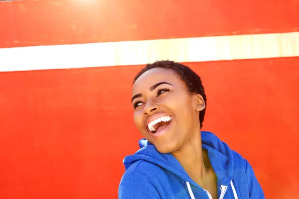 Woman smiling against wall — Stock Photo, Image