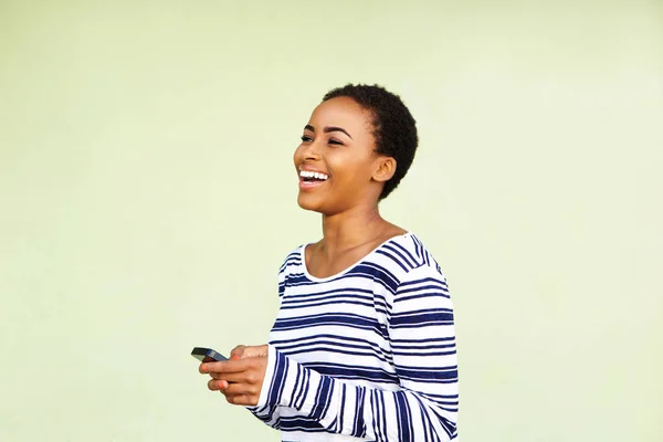 Vrouw met mobiele telefoon tegen groene muur — Stockfoto