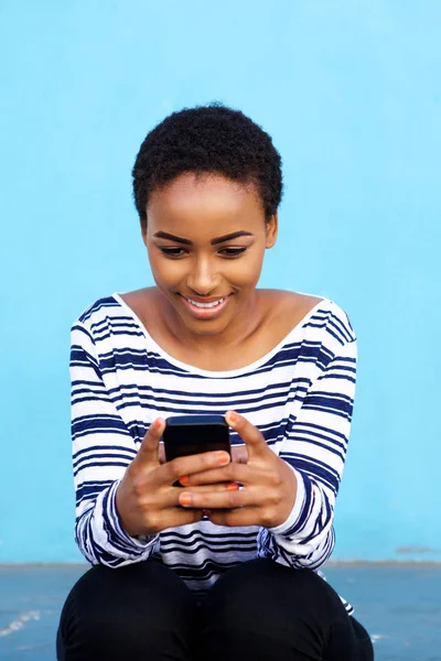 Mujer negra sentada con teléfono celular — Foto de Stock