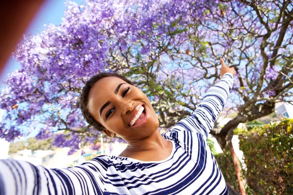 Mujer tomando selfie por árbol floreciente — Foto de Stock