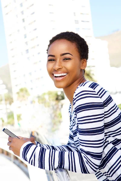 Mujer sosteniendo el teléfono celular fuera — Foto de Stock