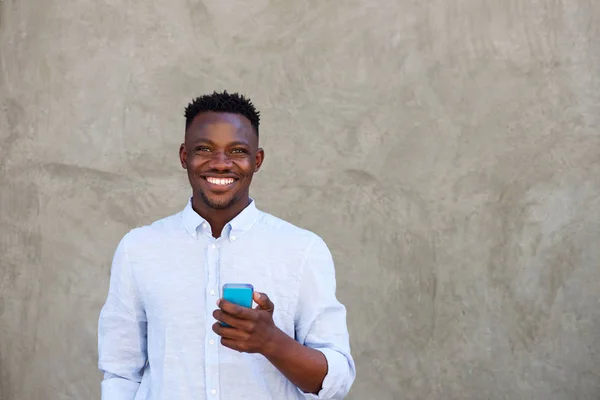 Uomo con cellulare in piedi a parete — Foto Stock