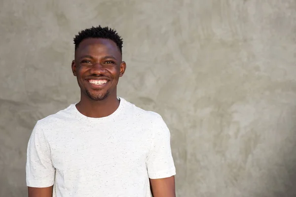 Homem africano sorrindo por parede — Fotografia de Stock