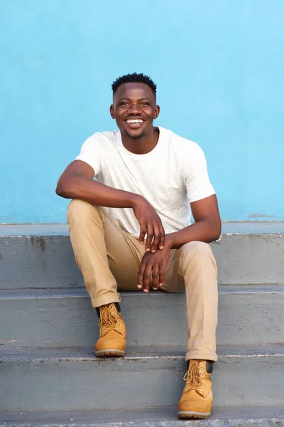 Homem sentado em passos e sorrindo — Fotografia de Stock