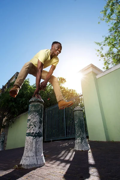 Homem saltar sobre poste de ferro — Fotografia de Stock