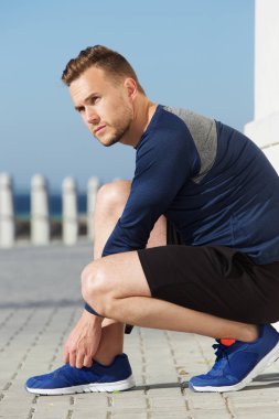 Ayakkabı bağcıkları bağlayan adam