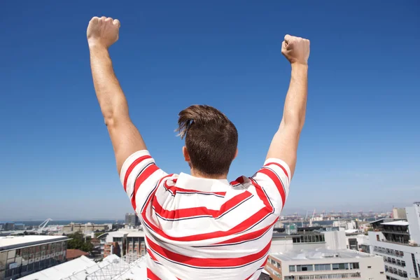 Man with arms raised outdoors — Stock Photo, Image