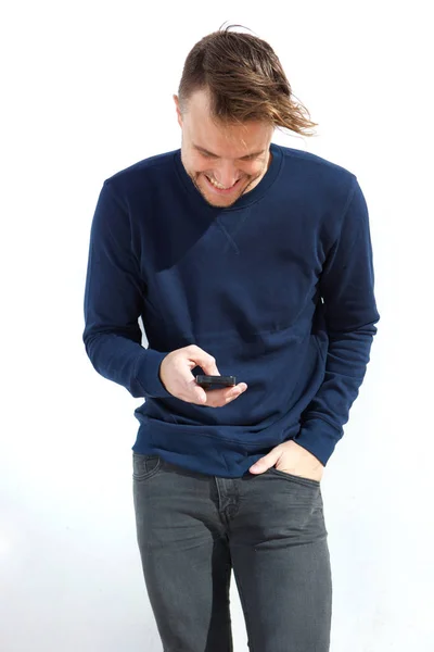 Улыбающийся мужчина смотрит на мобильный телефон — стоковое фото