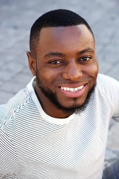Мужчина, улыбающийся снаружи в полосатой рубашке — стоковое фото