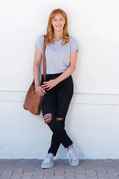 Mujer apoyada en pared blanca —  Fotos de Stock