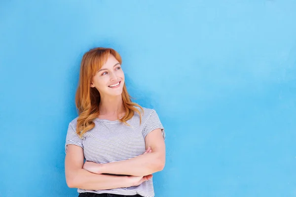 Woman standing against blue wall — Stock Photo, Image