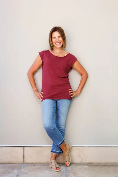 Mujer sonriendo contra la pared —  Fotos de Stock