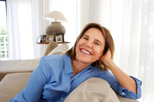 Женщина улыбается на диване — стоковое фото