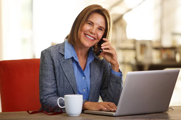 Kvinna med telefon och laptop — Stockfoto