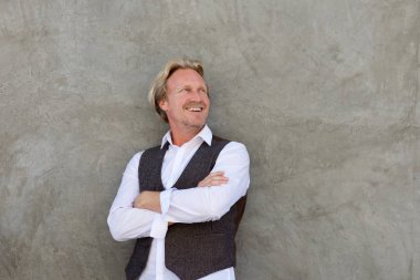 Orta yaşlı adam gülümsüyor. 