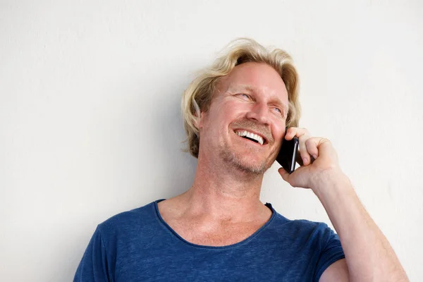 Uśmiechnięty mężczyzna przez biała ściana — Zdjęcie stockowe