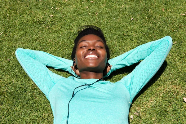 Чернокожая женщина, лежащая на траве — стоковое фото