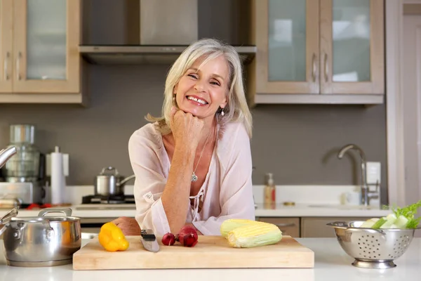 Woman leaning on kitchen counter — Stock Photo, Image