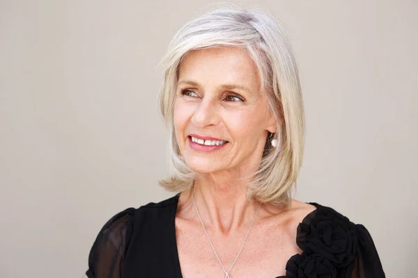 Smiling older woman thinking in black blouse — Stock Photo, Image