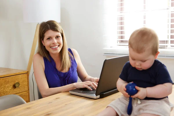 笔记本电脑和婴儿的女人 — 图库照片