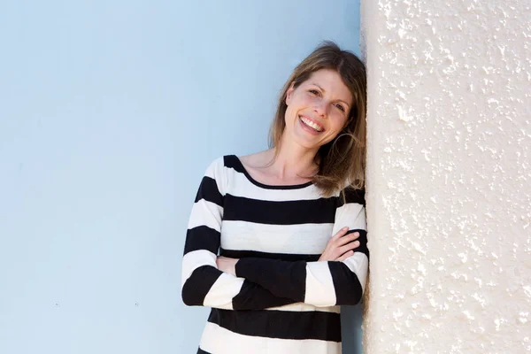 Mujer inclinada a la pared y sonriendo —  Fotos de Stock