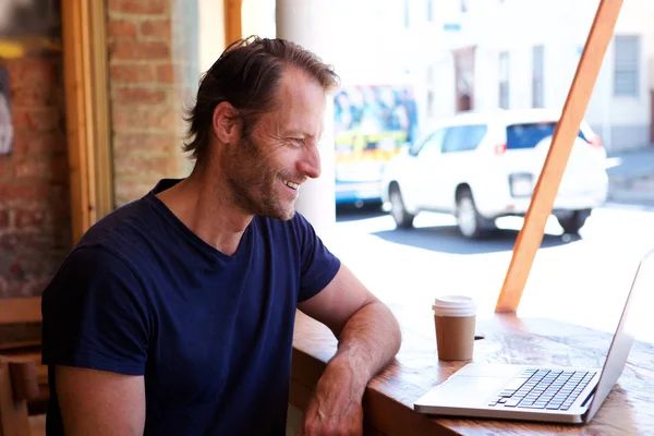 Człowiek z laptopa w kawiarni — Zdjęcie stockowe