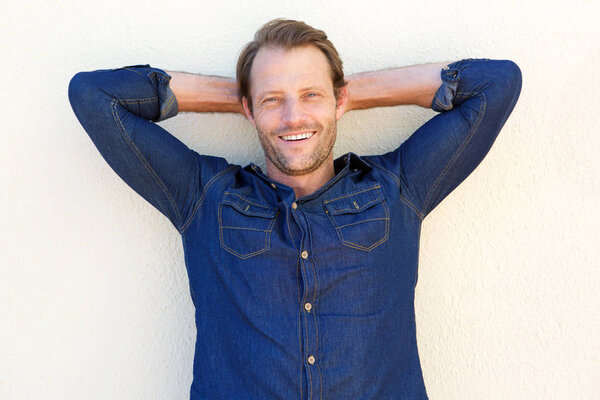 man with hands behind head