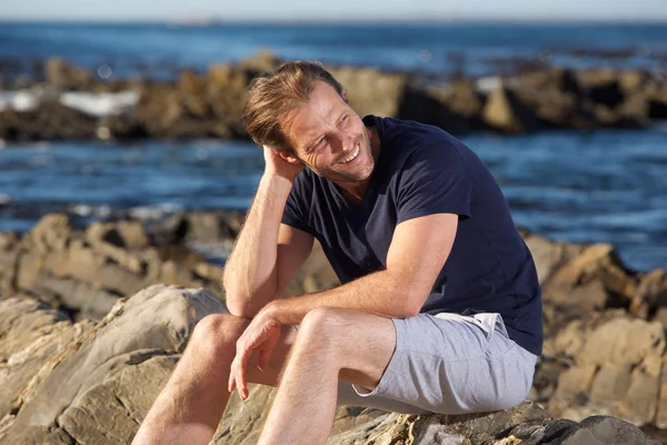 Mann sitzt am Meer — Stockfoto