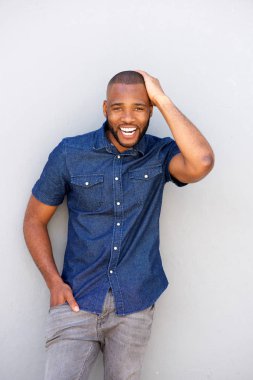 adam gülüyor ve duvara yaslanmış