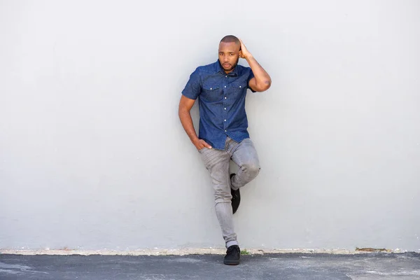 Homem posando por parede — Fotografia de Stock